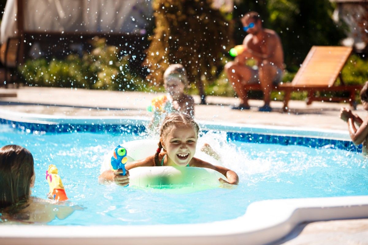 cheerful-children-playing-waterguns-rejoicing-jumping-swimming-pool (1)